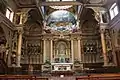 High altar, with altar rails and steps to the pulpit on the left.