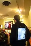 Back view showing the man facing away. Here we see the backwards facing video display on the jacket.