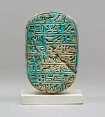 The back of a commemorative scarab of Amenhotep&nbsp;III, recording a lion hunt; 1390–1352&nbsp;BC; blue glazed steatite; length: 8&nbsp;cm; Metropolitan Museum of Art