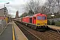 A DB Schenker Class 60 passes through the station with a freight train.