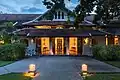 Entrance of Amantaka resort seen from outside at blue hour with candle lanterns.