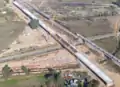 Construction in November 2016. The riverbed is near the top of the image, and CA 145 is in the foreground.