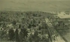 Sketch of Georgetown, Demerera, British Guiana showing the town on the left, people and horses walking on the main waterfront street, and the harbour on the right, filled with ships