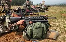 A U.S. Marine takes aim with an M16A2 fitted with the M203 40 mm grenade launcher.