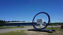 One Energy Wind for Industry" outside blue office building with wind turbine in background