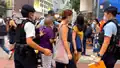 A PTU police officer pushing an elderly into defense line to stop and search
