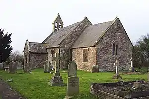 A red sandstone church with a small bellcote