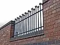 Iron railings with (metal) teddy bear heads, on the outside of the "Merrythought Village"