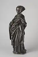 Figure I: Mourner with braided hair and a hanging veil. She wears a houppelande and a cloak tied with a band on her upper chest.