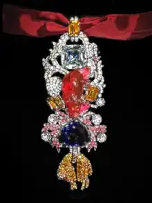 Detailed view of the recreated great Golden Fleece of king Louis XV of France. Below the 107 carats (21.4&nbsp;g; 0.75&nbsp;oz) spinel Côte de Bretagne hangs the French Blue diamond and the fleece itself, set with hundreds of yellow diamond replicas.