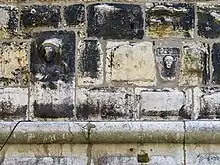 Reliefs of bust of Saint and human face with flower and date MCCLII (A.D. 1253) on the northern facade of the tower.