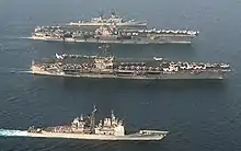 John F. Kennedy and Saratoga, a Forrestal-class carrier. Note the differences in island and aircraft elevator configuration.