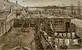  An extremely intricate drawing in exact perspective of a backyard seen from above. There is laundry hanging out to dry in the foreground and meadows with some buildings on the horizon in the background.